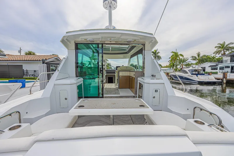 Low Hours!!! Yacht Photos Pics 2012 Cruisers Yachts 48 Cantius, rear view, docked with open cabin and seating area.