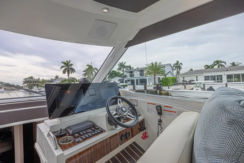 Low Hours!!! Yacht Photos Pics Interior view of 2012 Cruisers Yachts 48 Cantius helm with modern controls and waterfront scenery.