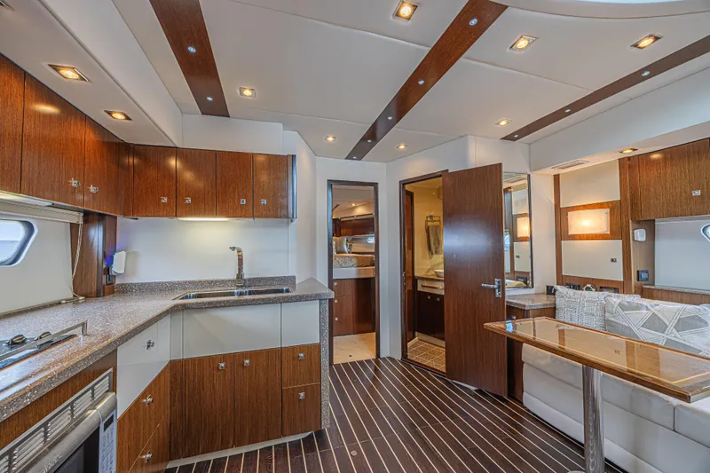 Low Hours!!! Yacht Photos Pics Luxurious interior of 2012 Cruisers Yachts 48 Cantius with modern kitchen and seating area.