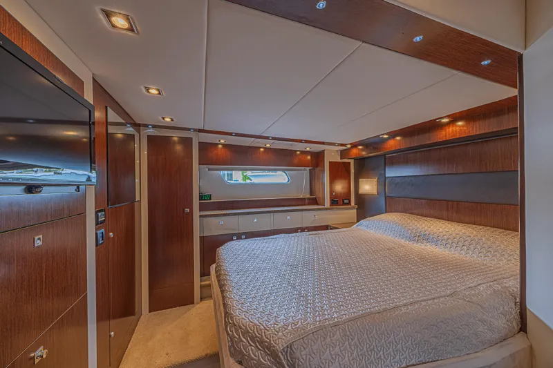 Low Hours!!! Yacht Photos Pics Luxurious 2012 Cruisers Yachts 48 Cantius bedroom with elegant wood paneling and modern lighting.