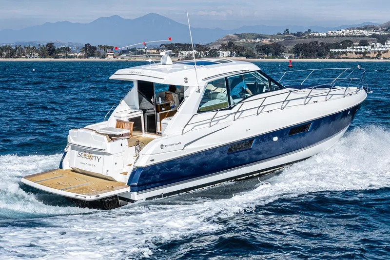 Serenity Yacht Photos Pics 2015 Cruisers Yachts 48 Cantius cruising on open water, scenic coastal backdrop.