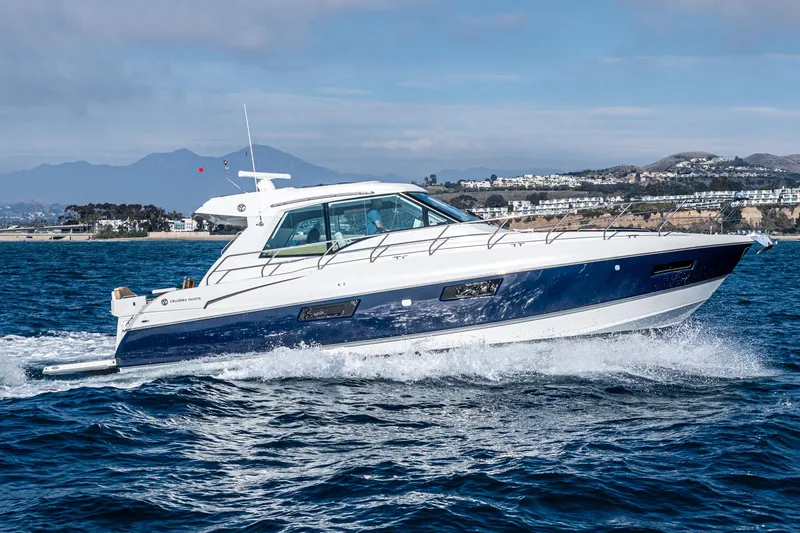 Serenity Yacht Photos Pics 2015 Cruisers Yachts 48 Cantius cruising on open water, scenic coastal background.