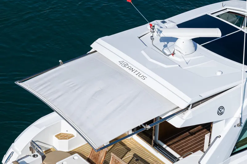 Serenity Yacht Photos Pics 2015 Cruisers Yachts 48 Cantius with extended sunshade on deck, docked on water.