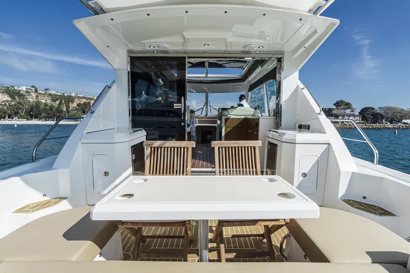 Serenity Yacht Photos Pics 2015 Cruisers Yachts 48 Cantius with outdoor seating, table, and ocean view.