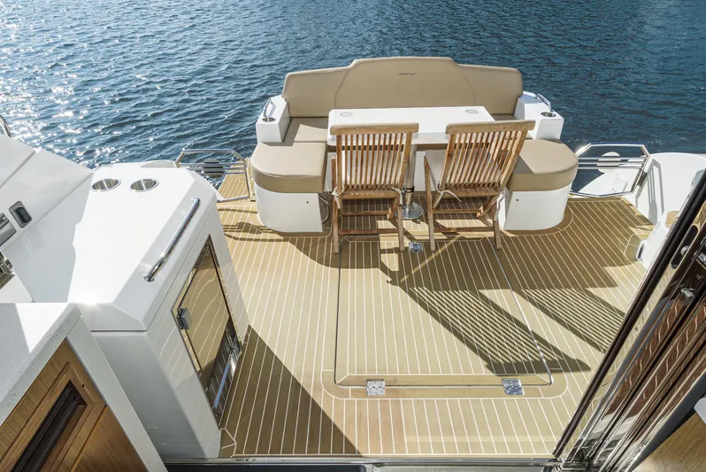 Serenity Yacht Photos Pics 2015 Cruisers Yachts 48 Cantius deck with seating and table overlooking water.