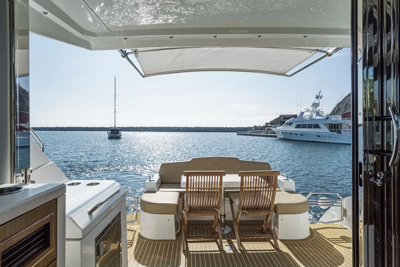 Serenity Yacht Photos Pics 2015 Cruisers Yachts 48 Cantius deck with seating, overlooking serene marina waters.