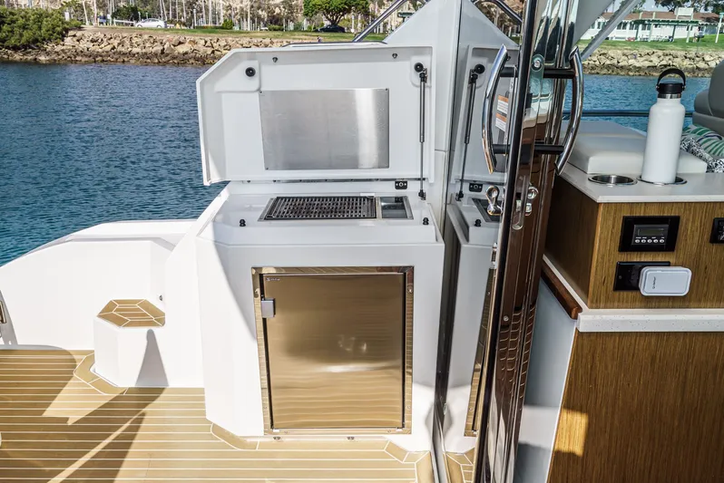 Serenity Yacht Photos Pics Outdoor kitchen on 2015 Cruisers Yachts 48 Cantius, featuring grill and storage, by the water.