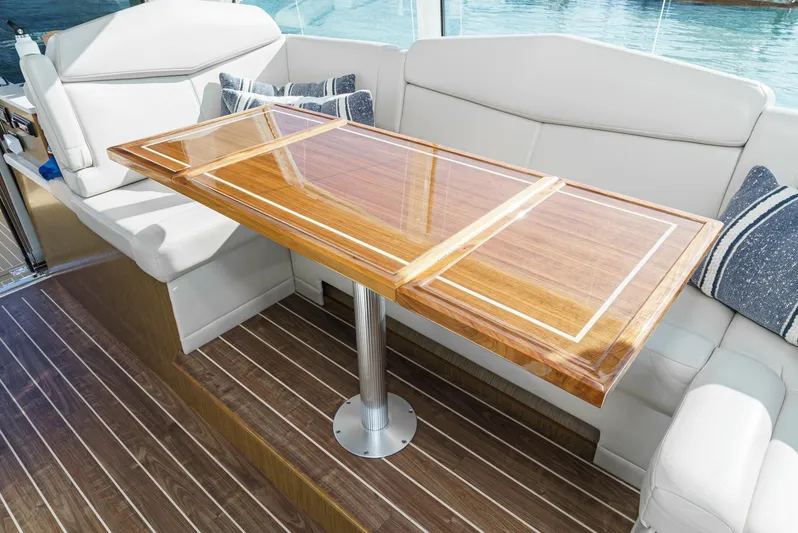 Serenity Yacht Photos Pics Luxurious seating area on 2015 Cruisers Yachts 48 Cantius with elegant wooden table.