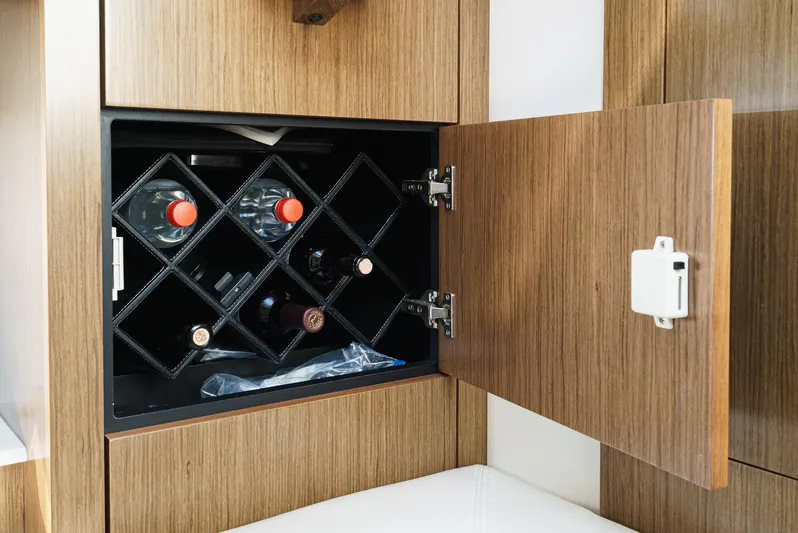 Serenity Yacht Photos Pics Wine storage cabinet in 2015 Cruisers Yachts 48 Cantius, featuring wooden finish and open door.