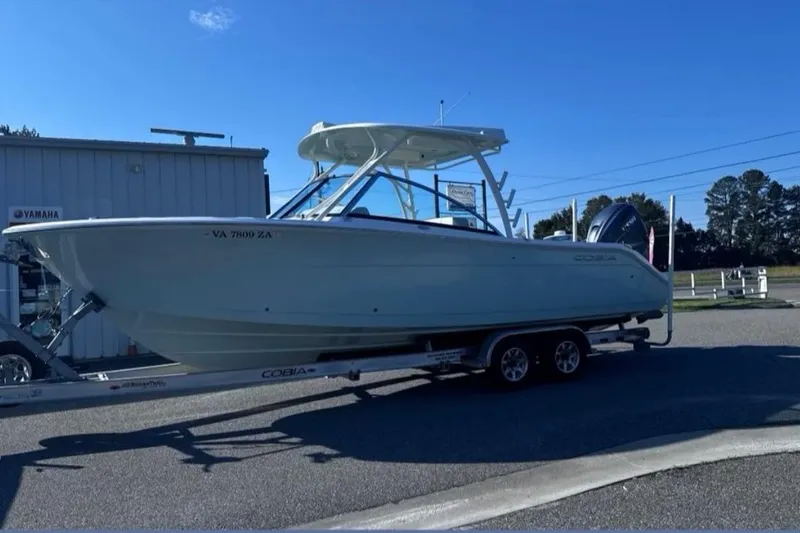 Hey Babe Yacht Photos Pics 2020 Cobia 280DC boat on trailer, parked outdoors near Yamaha building.