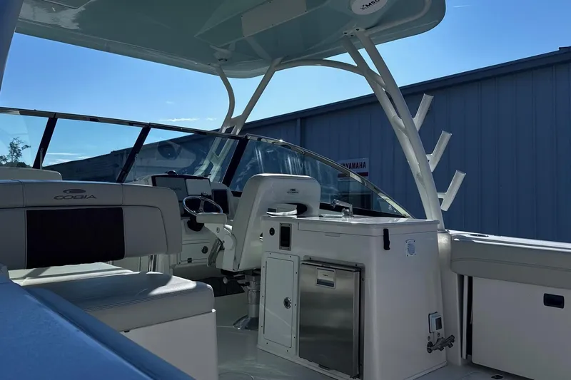 Hey Babe Yacht Photos Pics 2020 Cobia 280DC boat interior with seating and helm, under clear blue sky.