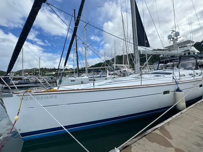Liquid Sunshine Yacht Photos Pics 2005 Beneteau 523 Oceanis sailboat docked in a marina under cloudy skies.