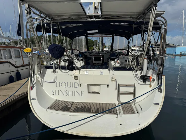 Liquid Sunshine Yacht Photos Pics 2005 Beneteau 523 Oceanis sailboat docked, rear view with "Liquid Sunshine" name visible.
