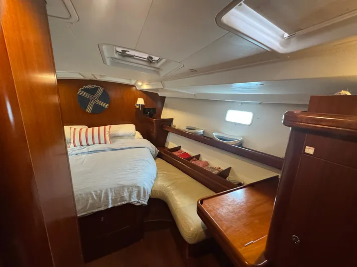 Liquid Sunshine Yacht Photos Pics Luxurious cabin interior of 2005 Beneteau 523 Oceanis yacht with cozy bed and wooden furnishings.