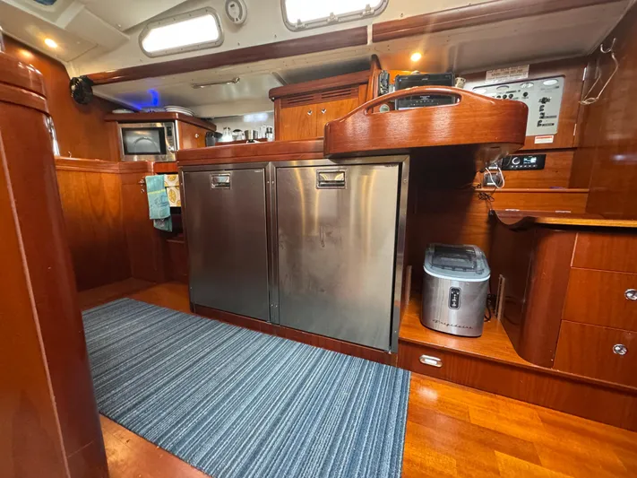 Liquid Sunshine Yacht Photos Pics Interior of 2005 Beneteau 523 Oceanis yacht with modern kitchen and wooden cabinetry.