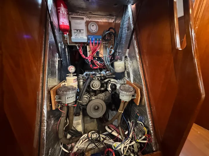 Liquid Sunshine Yacht Photos Pics Engine compartment of 2005 Beneteau 523 Oceanis sailboat, showcasing wiring and mechanical components.