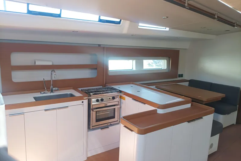 Ritual Yacht Photos Pics Modern interior of 2020 Beneteau First 53 yacht with kitchen and dining area.