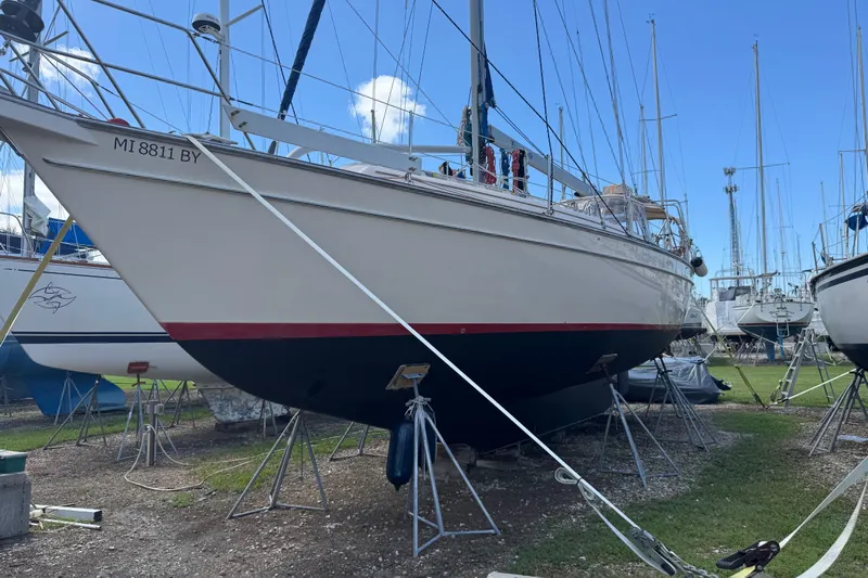True North Yacht Photos Pics 2004 Island Packet 420 sailboat on stands in a boatyard under clear blue sky.