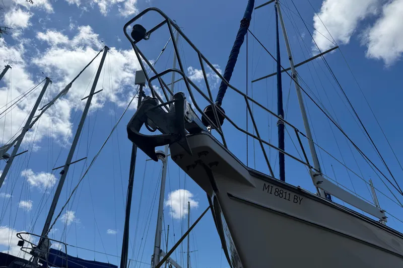 True North Yacht Photos Pics 2004 Island Packet 420 sailboat with masts against a blue sky and clouds.