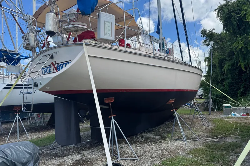 True North Yacht Photos Pics 2004 Island Packet 420 sailboat on stands, outdoor storage, clear sky background.