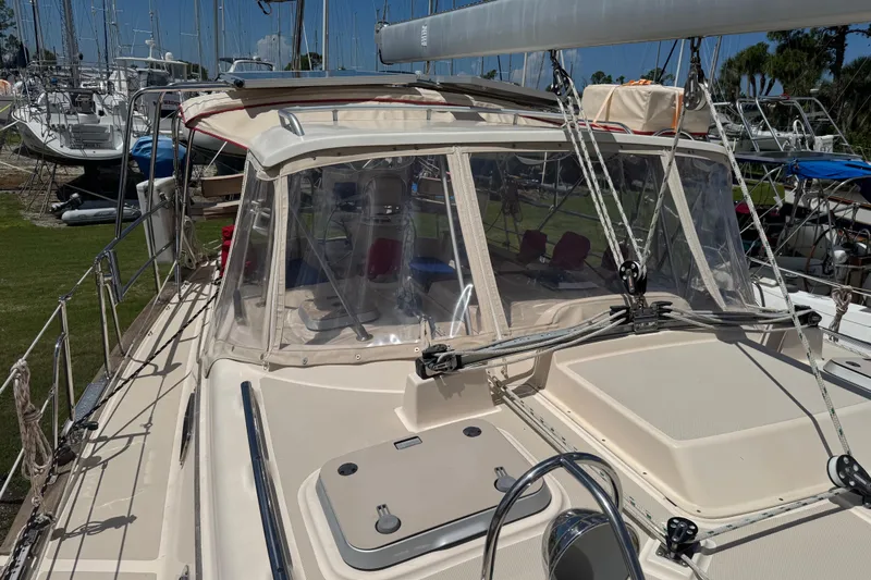 True North Yacht Photos Pics 2004 Island Packet 420 sailboat with clear cockpit enclosure, docked among other boats.