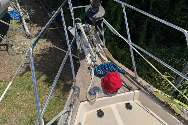 True North Yacht Photos Pics Deck of 2004 Island Packet 420 sailboat with railing, hose, and red cap.