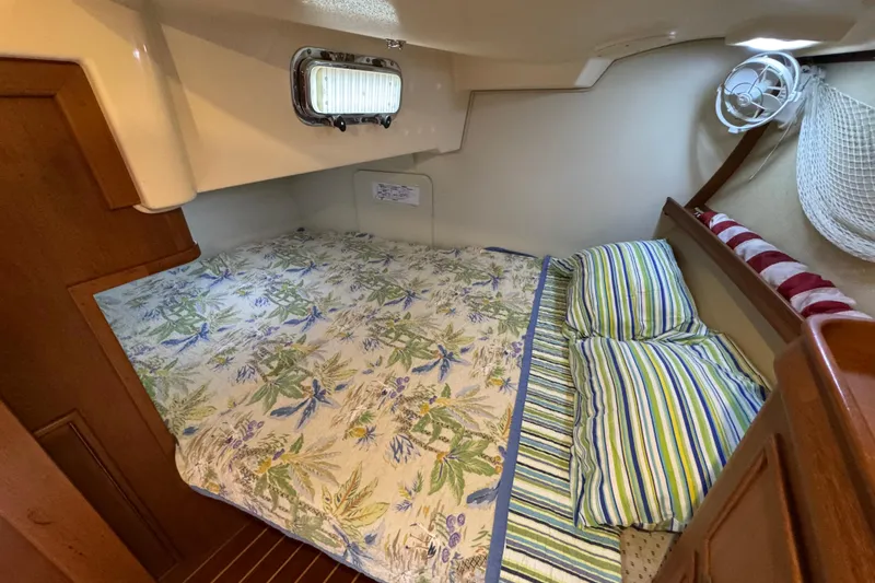 True North Yacht Photos Pics Cozy cabin interior of 2004 Island Packet 420 sailboat with floral bedding and striped pillows.