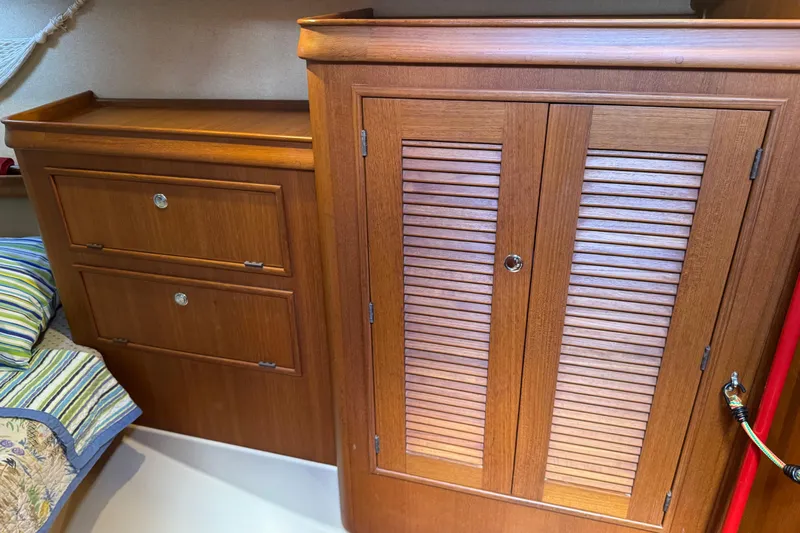 True North Yacht Photos Pics Wooden cabinetry inside a 2004 Island Packet 420 sailboat, featuring drawers and a louvered door.