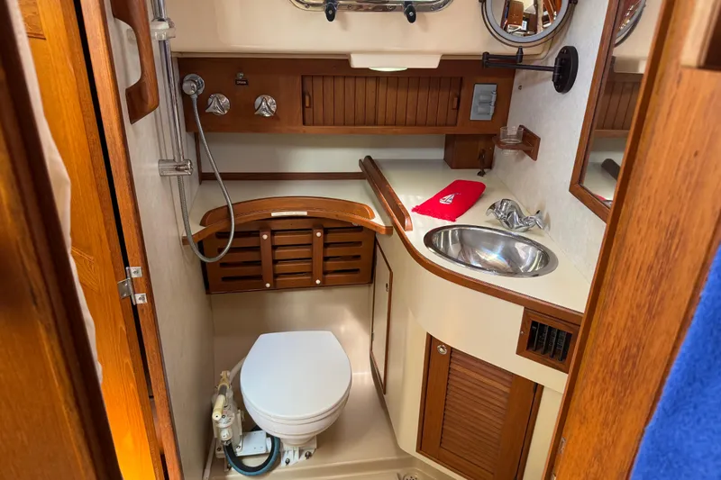 True North Yacht Photos Pics 2004 Island Packet 420 yacht bathroom with wooden cabinetry, sink, and toilet.
