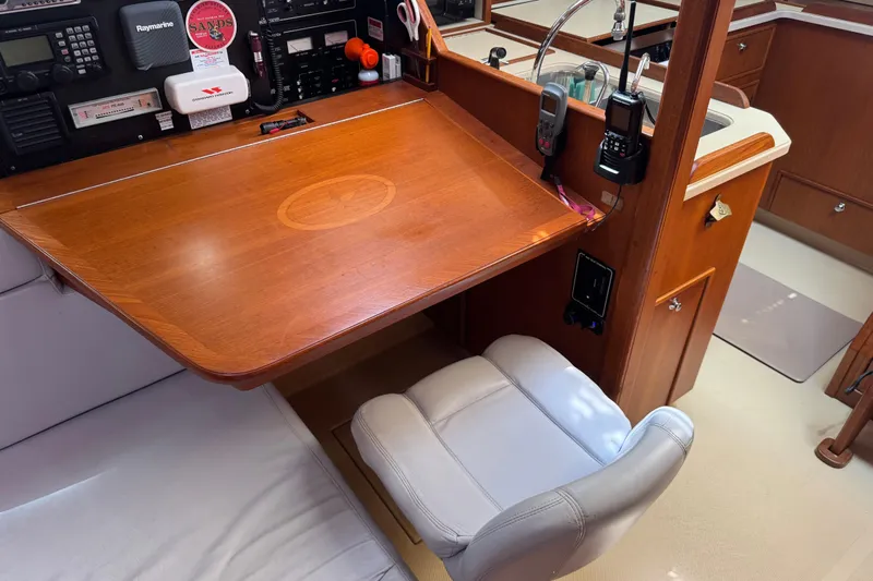 True North Yacht Photos Pics Navigation station in 2004 Island Packet 420 yacht with wooden desk and communication equipment.