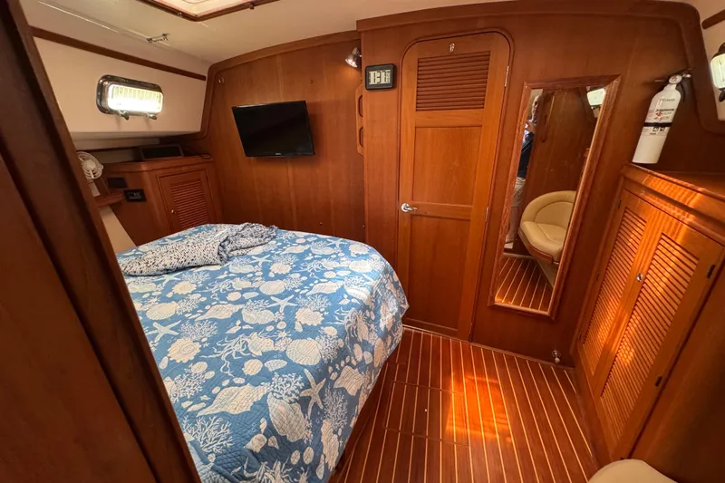 True North Yacht Photos Pics Cozy cabin interior of 2004 Island Packet 420 sailboat with nautical-themed bedding.