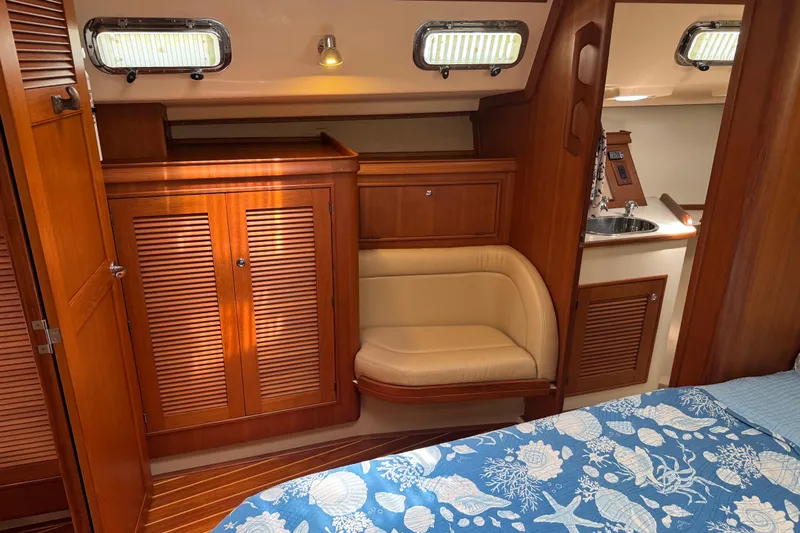True North Yacht Photos Pics Interior of 2004 Island Packet 420 yacht with wood cabinetry and cozy seating area.