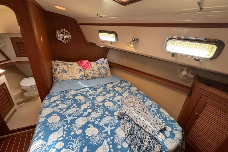 True North Yacht Photos Pics Cozy cabin interior of 2004 Island Packet 420 sailboat with nautical-themed bedding.