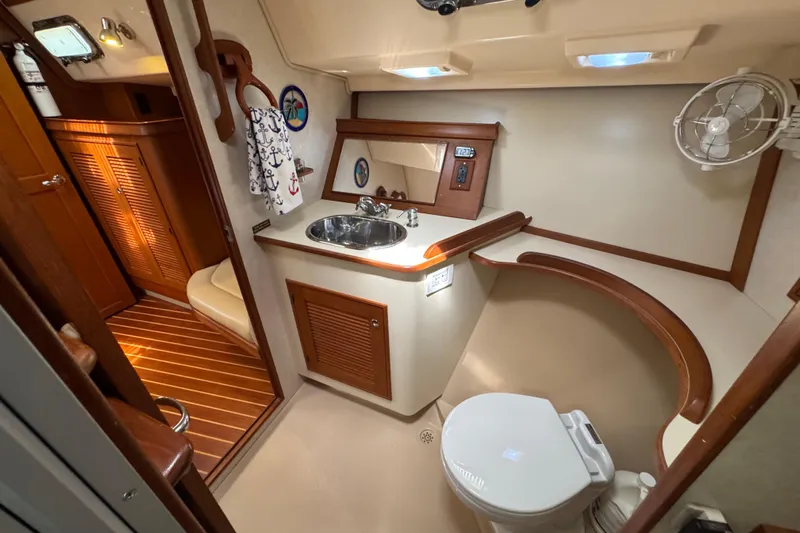 True North Yacht Photos Pics 2004 Island Packet 420 yacht bathroom with sink, toilet, and wooden accents.