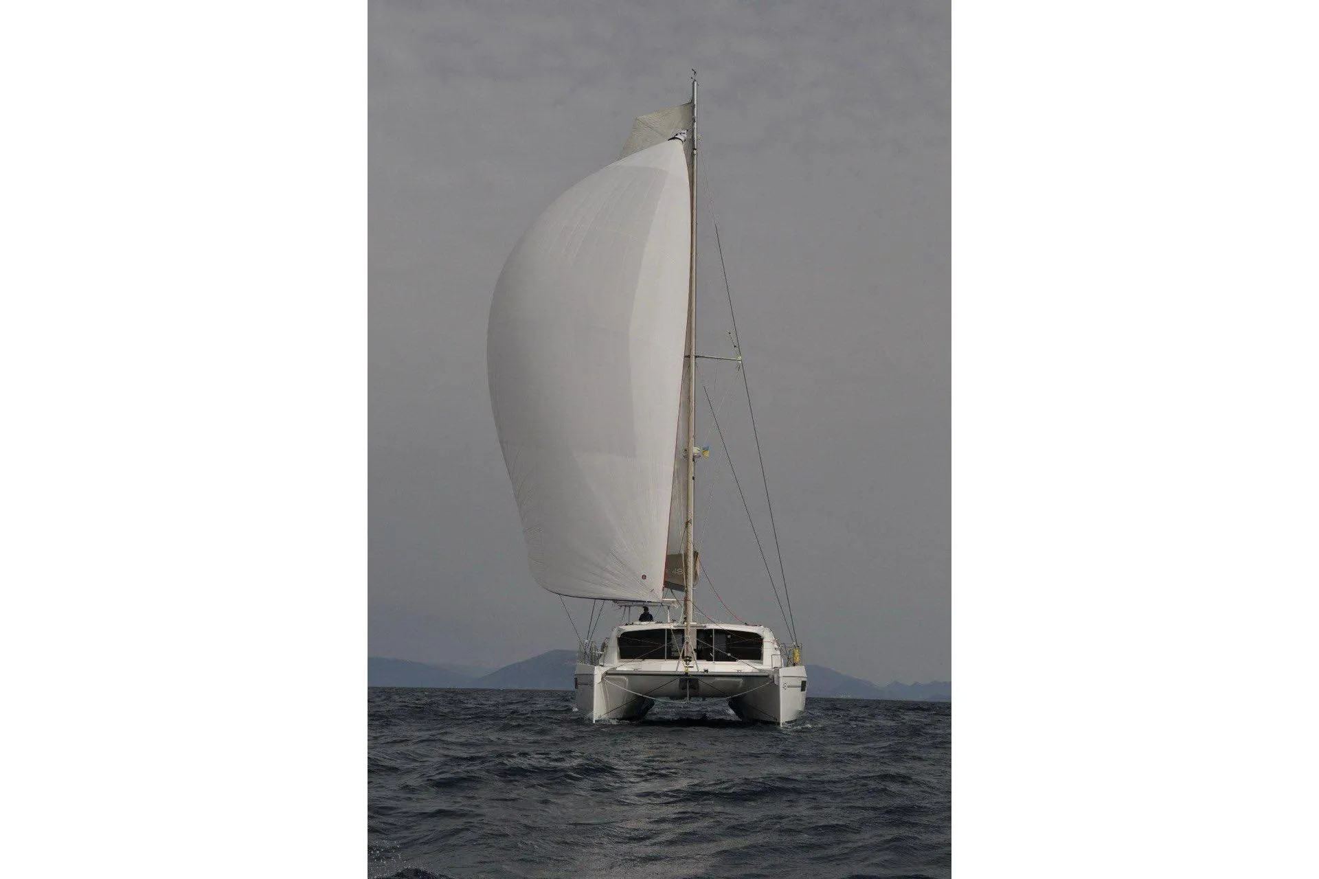 2015 Leopard 48 catamaran sailing on open water with full sails.