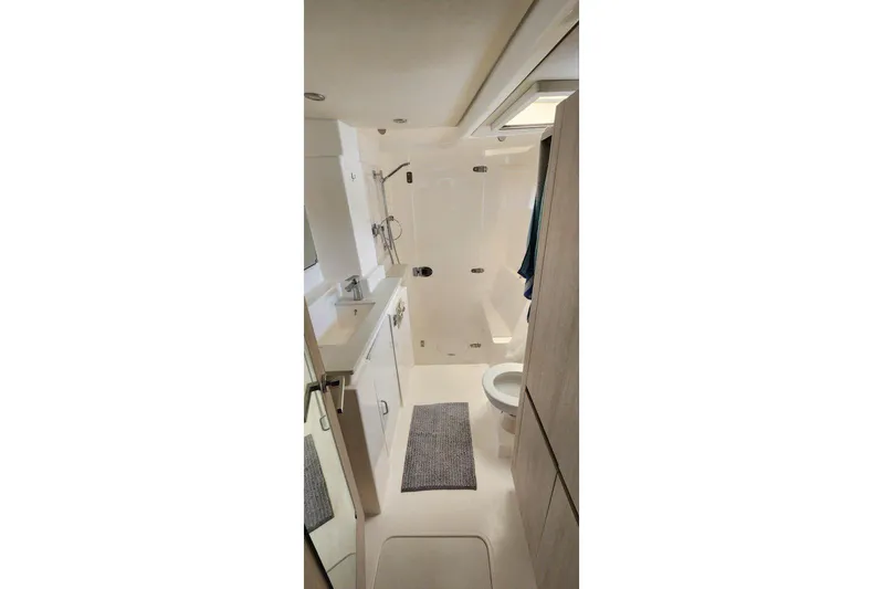 Jolly Dacha Yacht Photos Pics Modern bathroom interior on 2015 Leopard 48 yacht, featuring shower, sink, and toilet.
