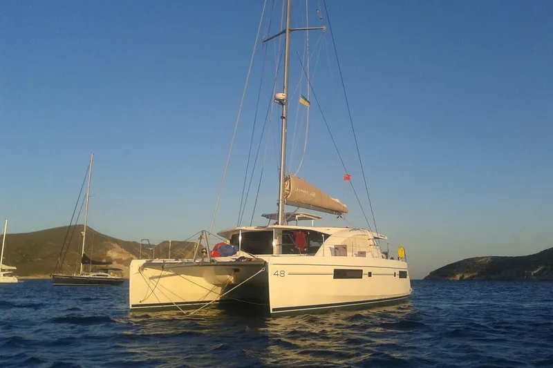 Jolly Dacha Yacht Photos Pics 2015 Leopard 48 catamaran sailing on calm waters at sunset.