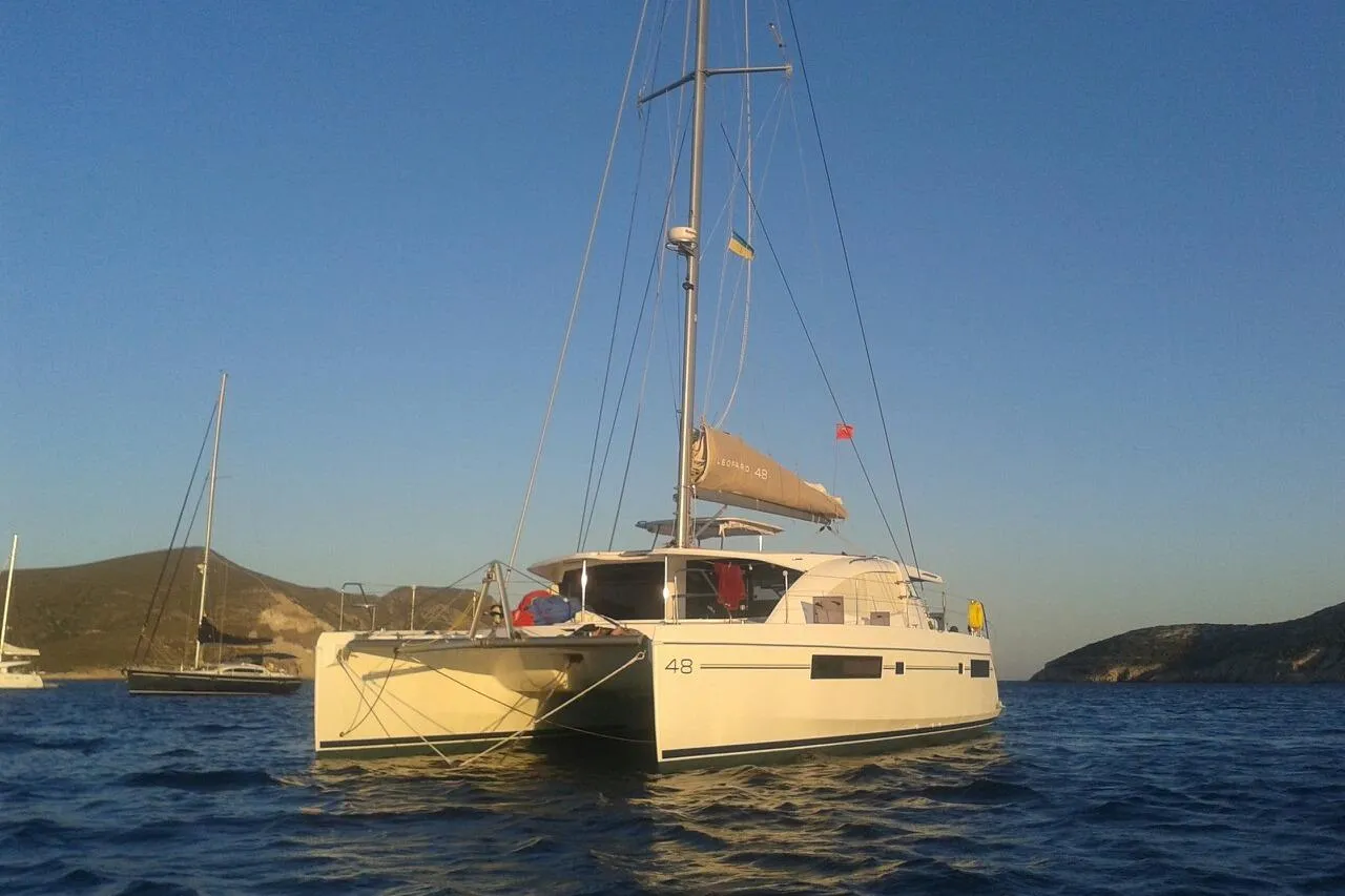 2015 Leopard 48 catamaran sailing on calm waters at sunset.