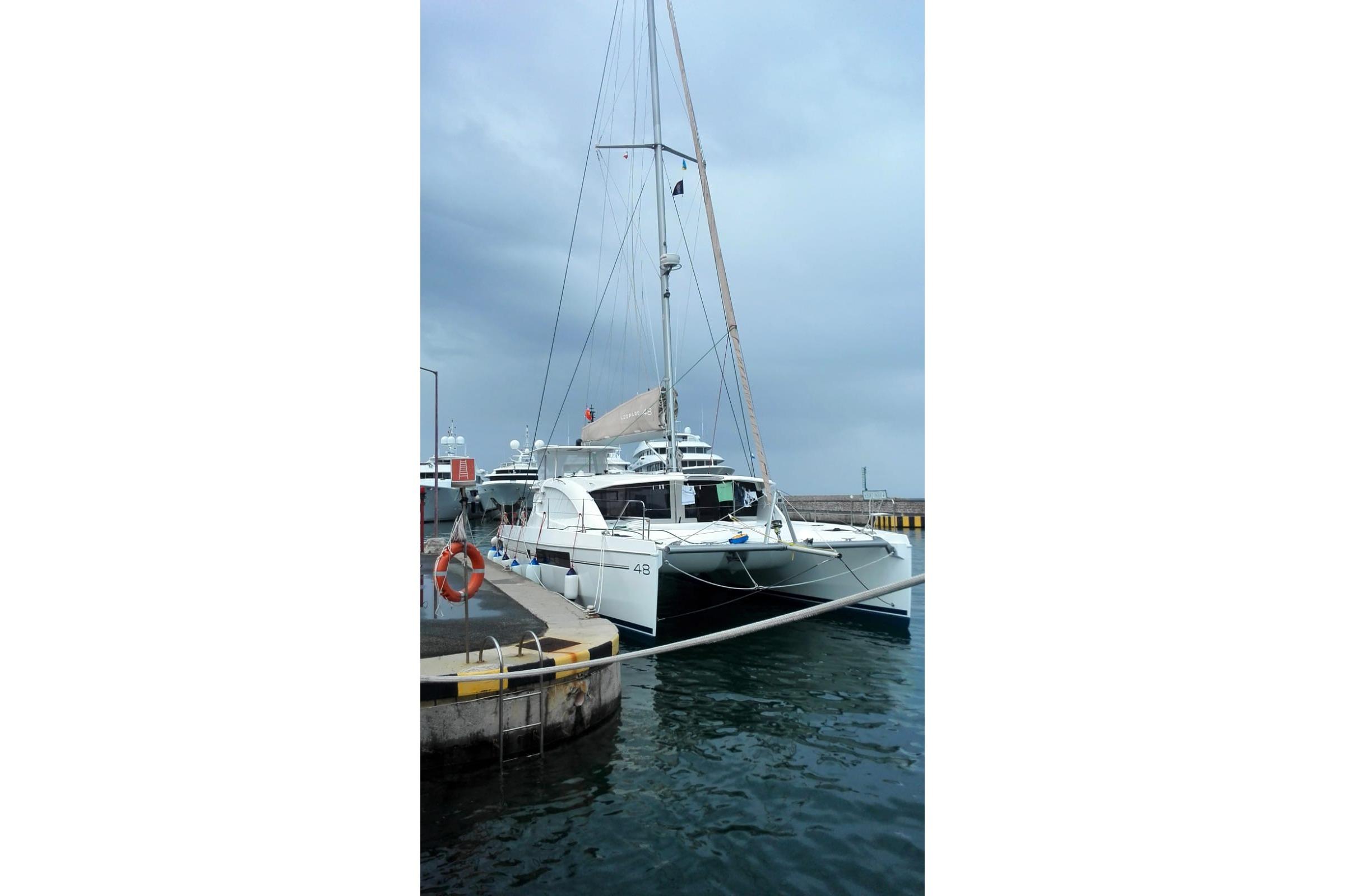 Leopard 48 catamaran docked at marina, 2015 model, under cloudy sky.