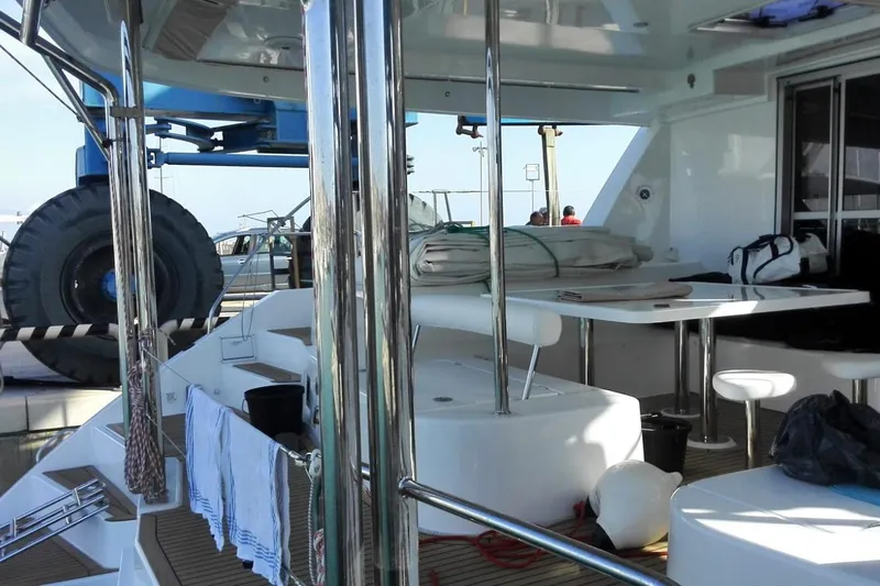 Jolly Dacha Yacht Photos Pics 2015 Leopard 48 yacht interior with seating and table, docked near large equipment.