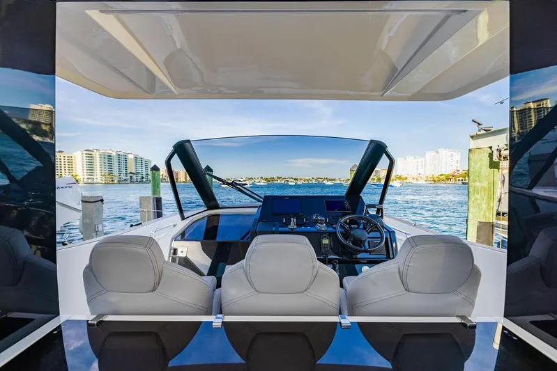  Yacht Photos Pics Astondoa 377 yacht cockpit, 2023 model, with modern steering and seating, overlooking waterfront.