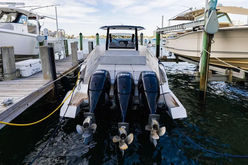  Yacht Photos Pics 2023 Astondoa 377 boat docked, featuring triple outboard engines, in a marina setting.