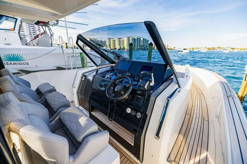  Yacht Photos Pics 2023 Astondoa 377 yacht helm with luxurious seating and modern controls, docked by the water.