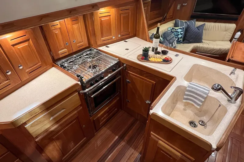  Yacht Photos Pics Luxurious 2017 Tartan 4300 yacht kitchen with wooden cabinetry, stove, and sink.