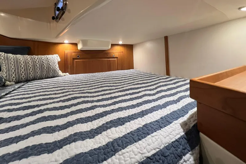  Yacht Photos Pics Cozy cabin interior of 2017 Tartan 4300 yacht with striped bedding and wooden accents.