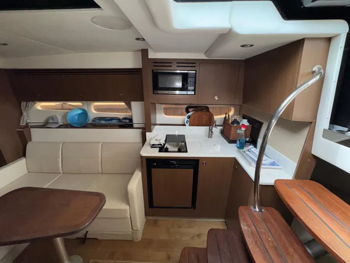 Idylwilde Yacht Photos Pics Interior of 2018 Sea Ray Sundancer 350 Coupe with kitchenette and seating area.
