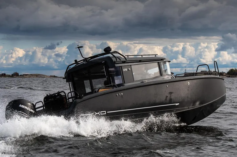  Yacht Photos Pics 2026 XO Boats EXPLR 10S PLUS navigating choppy waters under a cloudy sky.