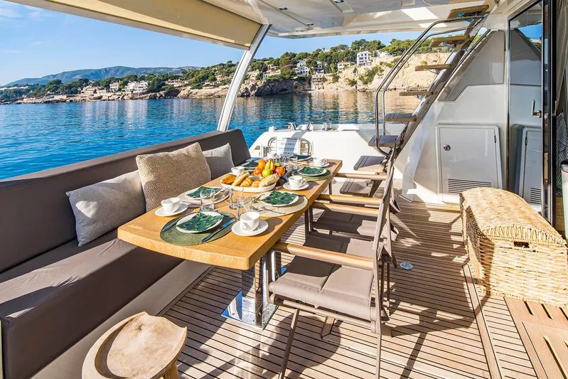  Yacht Photos Pics Luxurious 2016 Prestige 680 yacht deck with dining setup, overlooking serene coastal waters.