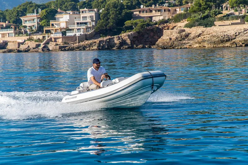  Yacht Photos Pics Man driving a Prestige 680 boat on clear blue water, 2016 model.