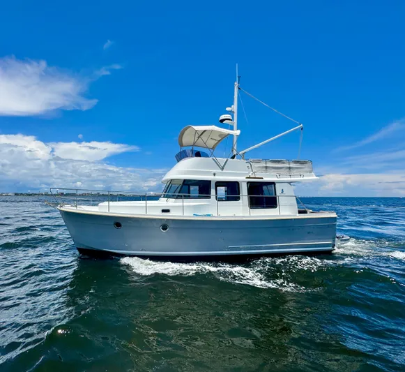 Amour Yacht Photos Pics 2018 Beneteau Swift Trawler 34 cruising on open water under a clear blue sky.